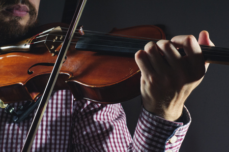 Violin in the hands of the musician. Violinist plays music.の写真素材