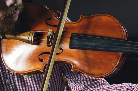 Violin in the hands of the musician. Violinist plays music.の写真素材