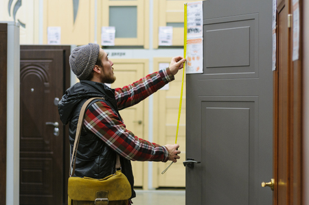EKATERINBURG, RUSSIA - JANUARY, 8, 2018: A young man chooses interroom door in the hardware store
の写真素材