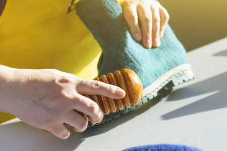 The master makes warm boots from natural felted wool. Handmade shoes.の写真素材
