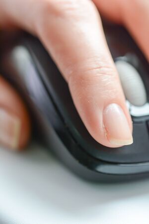 Woman hand using an optical computer mouseの写真素材