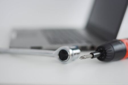 Computer support with a notebook and screwdriverの写真素材