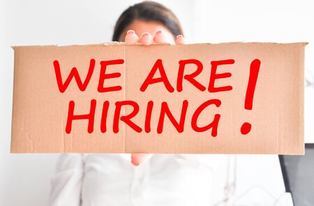 We are hiring text with businesswoman holding a cartonの写真素材