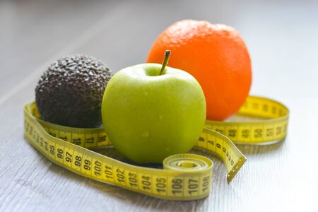 Measurement of diet results concept with fruits on wooden backgroundの写真素材