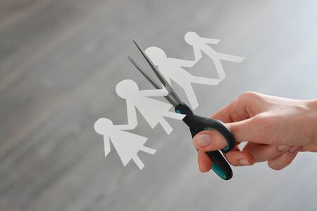 Family divorce concept with human paper shapes and scissors suggesting relationship problemsの写真素材