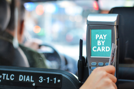 Close-up of a hand paying a taxi ride by credit cardの写真素材
