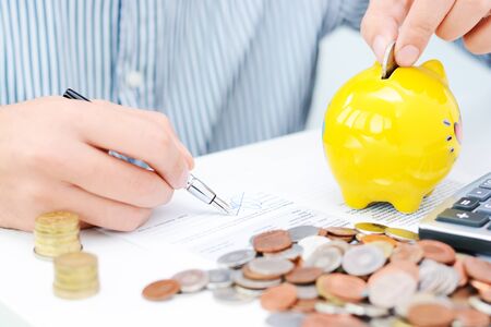 Tax calculation or new loan agreement with hand calculator and coinsの写真素材