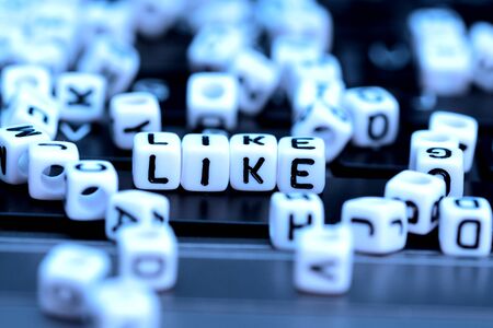 Close-up of Like word from white cubes on notebookの写真素材