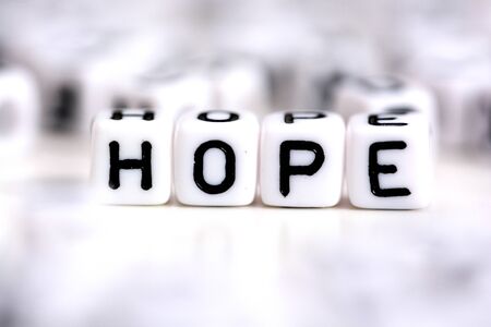 Hope word made from plastic alphabet blocks, stands in white background.の写真素材