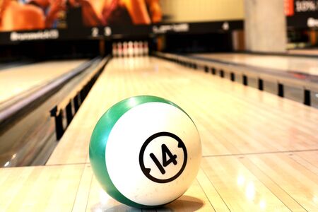 Game concept with Ball on bowling wooden floor against ten pins