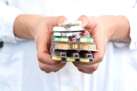 Woman holding a stack of pills blisters in her handsの写真素材