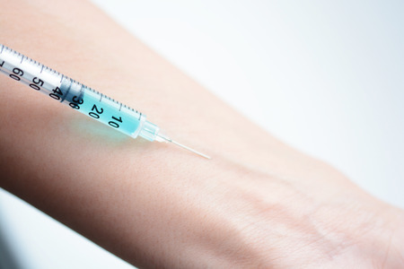 Close-up of a human arm getting an injectionの写真素材