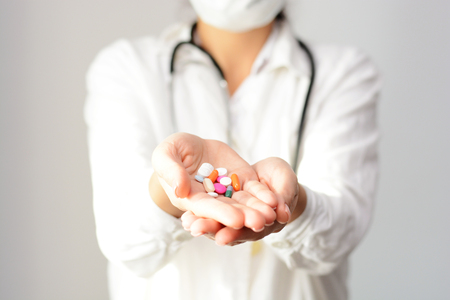 Cropped shot of a female doctor displaying a handful of tablets and pills in her palmの写真素材