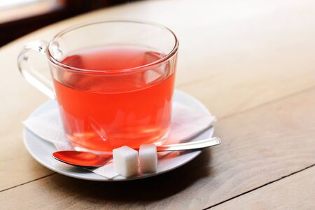 Fruit tea in a glass cup with sugar on wooden backgroundの写真素材