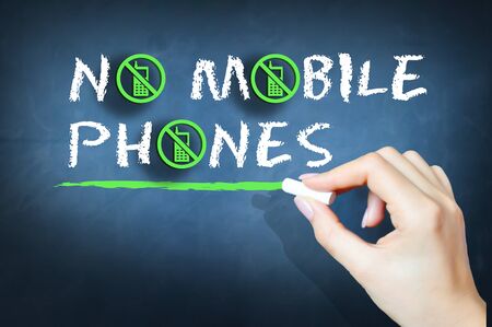 No mobile phones handwritten text on chalkboardの写真素材