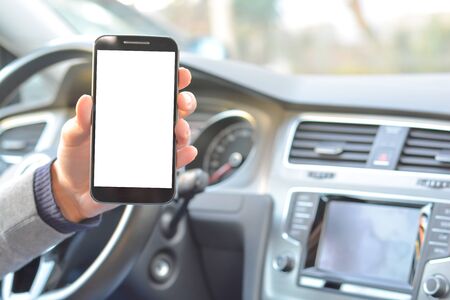 Smartphone hold by man inside a car while drivingの写真素材