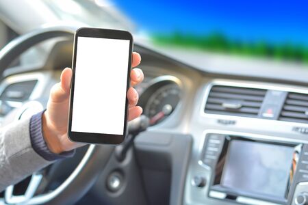 Smartphone hold by man inside a car while drivingの写真素材