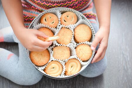 Child holding a box of Danish butter cookies