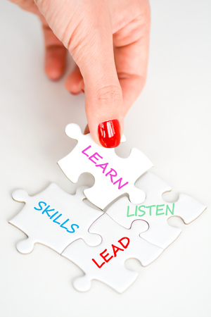 Woman hand fitting the right piece of puzzle suggesting business  networking conceptの写真素材
