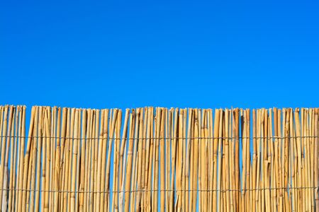 Bamboo or cane fence with blue skyの写真素材