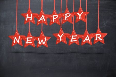 Happy new year wish with red stars isolated on blackboard backgroundの写真素材