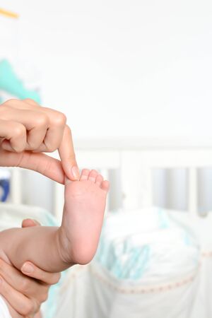 Mother holding baby feet in her palmsの写真素材