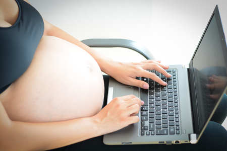 Young pregnant woman using a laptop computer at homeのeditorial素材