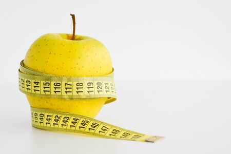 Apple and measuring tape suggesting diet concept