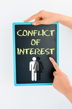 Conflict of interest concept on small blackboardの写真素材