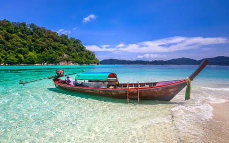 Long tail boat on white sand beach on tropical island, Koh Lipe, Andaman sea, Thailandの写真素材