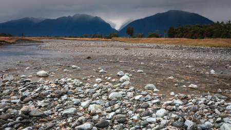 River from Fox glacier with rock foreground, New Zealand