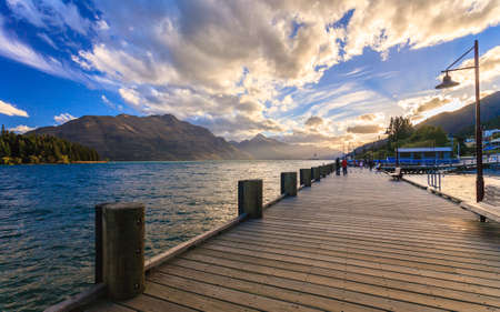 Wooden pier with beautiful lake Wakatipu, Queenstown, New Zealandの写真素材