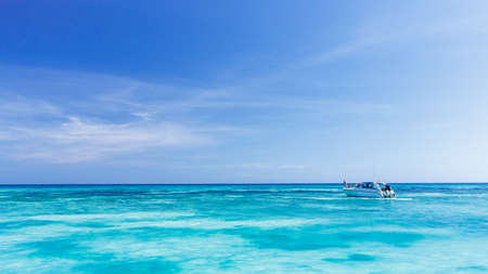 A tourist speed boat in crystal clear blue sea at tropical island, Tachai, Thailandの写真素材
