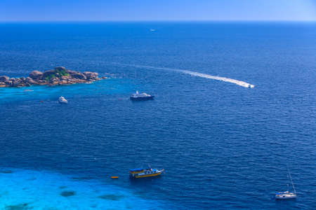 Aerial view of a beach with some motorboats in the turquoise sea の写真素材