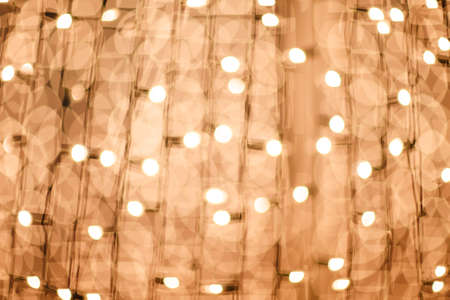 Golden Christmas lights at night. Beautiful blurred background.の写真素材