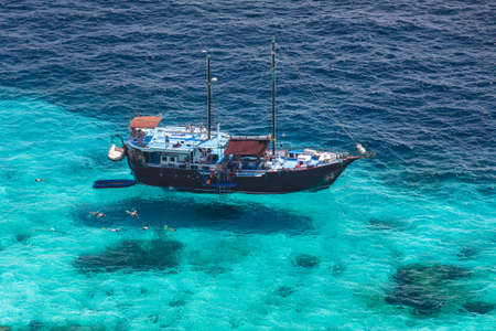 Aerial view of the tropical island, clear blue sea and a tourist boat on a sunny dayのeditorial素材