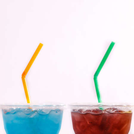Multi-color cool soft drink with straw on isolated white background
