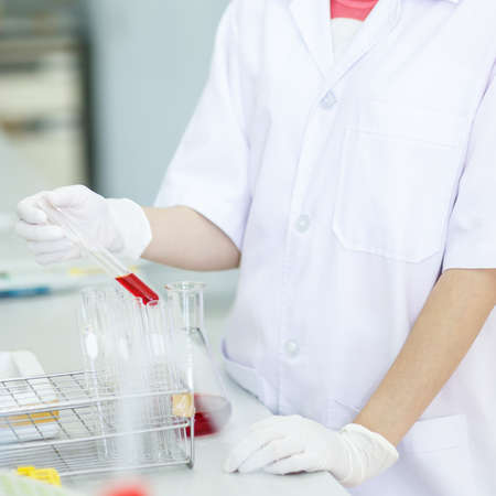 scientist examining chemical in test tube at biomolecular laboratory