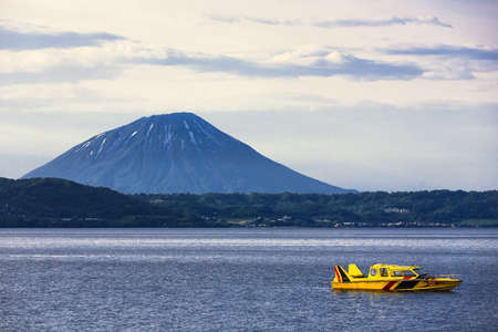 Cruising at Lake Toya with Mt. Yotei in background, Hokkaido, Japanのeditorial素材