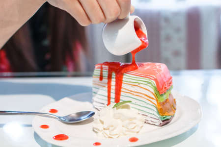Rainbow crepe cake filling by strawberry juice with whipped creamの写真素材