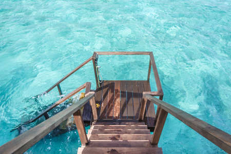 Stair down to crystal clear ocean from water villa private balcony, Maldivesの写真素材