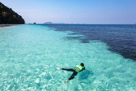 Man snorkeling in crystal clear water, Andaman sea, Thailandの写真素材