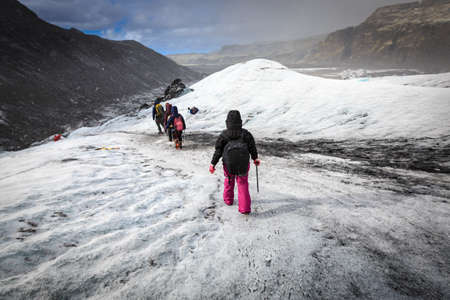 Group of hiker walk on glacier during heavy snow fall on Solheimajokull, Icelandの写真素材