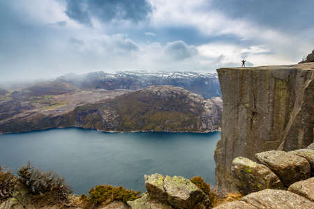 Man standing on a cliff of Pulpit rock (Preikestolen), Norwayのeditorial素材