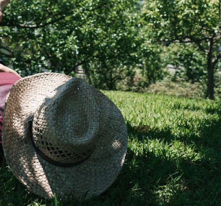 Straw hat on the green grass background in the shadeの写真素材