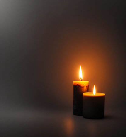 Two burning candles on a dark background. Copy space for your text.の素材