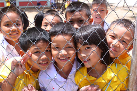 Khon Kaen,Thailand June 9, 2011 group of joyful asian kids posing from net of schoolyardのeditorial素材