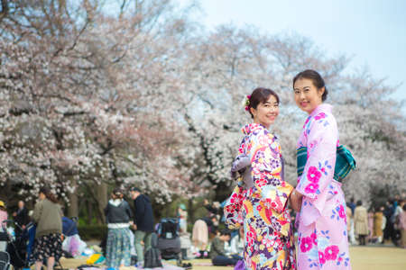 Tokyo,Japan- Mar 27,2019 : two asian women in traditional japanese kimono enjoy sakura festival at shinjuku gyoen cherry blossom in springのeditorial素材