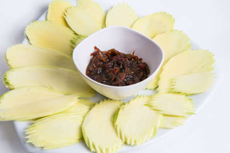 sliced mango with sweet fish sauce serve in white plateの写真素材