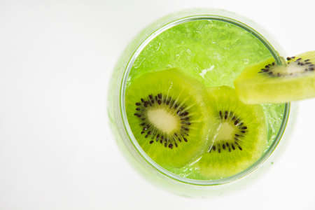 top view of green kiwi drink with iced in a glass decorated with sliced kiwiの写真素材